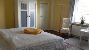 ein Schlafzimmer mit einem Bett, einem Stuhl und einem Fenster in der Unterkunft Schöne Ferienwohnung Im alten Gasthaus in Stoltebüll in Stoltebüll