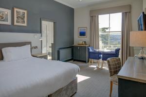 a hotel room with a bed and a desk and a table at Lansdown Grove Hotel in Bath