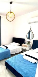 a bedroom with two beds and a chandelier at BLUE LATSI in Lachi
