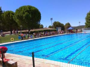 a large swimming pool with people standing around it at Desconexión y paz, cabaña en la sierra in Albalate de Zorita