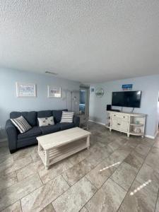 een woonkamer met een bank en een tv bij Island House Beach Resort 4 in Point O'Rocks