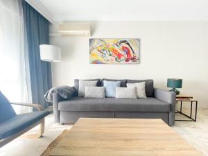 a living room with a couch and a painting at Holidays2Malaga Tomas de Echeverria 150 mts to Beach & High Speed wifi & Parking in Málaga