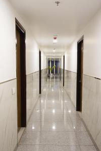 a hallway of a building with white walls and black doors at Gallivanto Inn in New Delhi