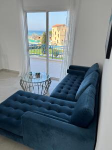 un divano blu in soggiorno con una grande finestra di BLUE LATSI a Lachi