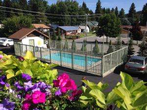 een hek rond een zwembad in een tuin met bloemen bij Linderhof Inn in Leavenworth
