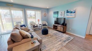 a living room with a couch and a flat screen tv at AH-A100 First Floor Condo, Newly Remodeled, Overlooks Shared Pool in Port Aransas