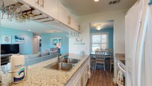 a kitchen with a sink and a living room at AH-A100 First Floor Condo, Newly Remodeled, Overlooks Shared Pool in Port Aransas