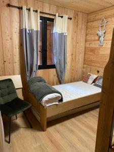 um quarto com uma cama e uma cadeira num camarote em chalet au pieds des pistes le cambre aze em Bolquere Pyrenees 2000