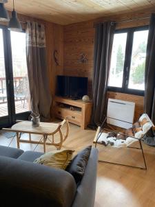 uma sala de estar com um sofá e uma televisão em chalet au pieds des pistes le cambre aze em Bolquere Pyrenees 2000