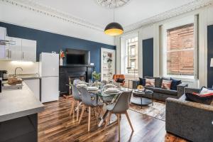 a kitchen and a living room with a table and chairs at The Renfrew Residence 4-bedroom, city centre in Glasgow