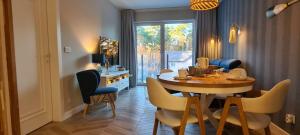 una sala da pranzo con tavolo, sedie e finestra di Apartament Niebieskie Lato Mielno a Mielno