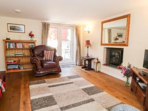 - un salon avec une chaise et une cheminée dans l'établissement Blackbird Cottage, à Telford