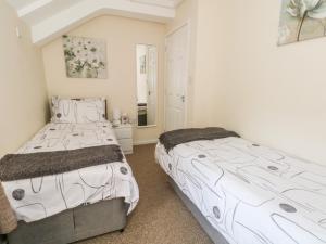 um quarto com 2 camas e um espelho em Blackbird Cottage em Telford