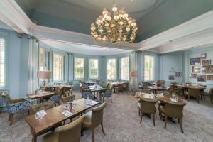 a living room filled with tables and chairs at Lansdown Grove Hotel in Bath