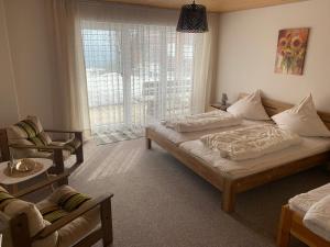 1 dormitorio con cama, sofá y ventana en Ferienwohnung- Pfenniggeiger, en Philippsreut