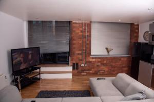 a living room with a couch and a television at Neptune Apartments in Leeds