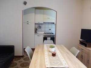 une salle à manger avec une table et une cuisine dans l'établissement Appartamento Graziella, à Mollia