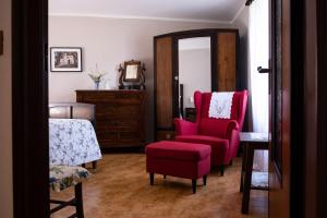 ガルニャーノにあるLocanda Genzianellaの赤い椅子と鏡付きのベッドルーム