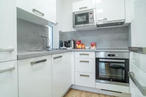 a kitchen with white cabinets and a microwave at Hotel Smrž in Sepekov
