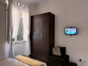 フィレンツェにあるLa Casa di Gretaのベッドルーム1室(キャビネット付)、壁掛けテレビが備わります。