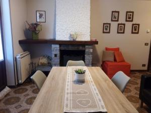 - une table et des chaises dans le salon doté d'une cheminée dans l'établissement Appartamento Graziella, à Mollia