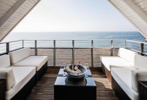 - un balcon avec des canapés et un bol sur une table dans l'établissement Seevital Hotel, à Langenargen