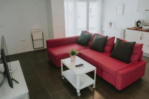 a living room with a red couch and a table at Apartamentos ZHR 2 in Zahara de los Atunes