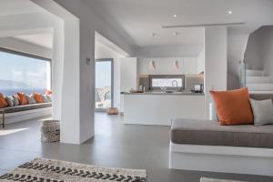 Una sala de estar con un sofá y una cocina. en Villa Aether - Infinity Pool Villa Mykonos, en Mykonos ciudad