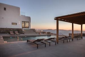 Villa con piscina y algunas sillas en Villa Aether - Infinity Pool Villa Mykonos, en Mykonos ciudad