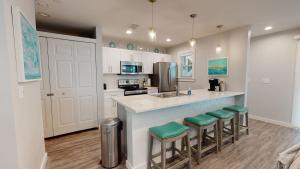 a kitchen with a counter with stools and a sink at AH-J132 Newly remodeled first floor condo near Marina in Port Aransas