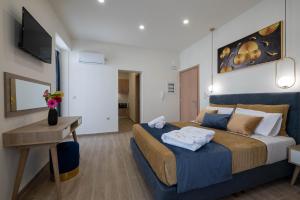a bedroom with a large bed with towels on it at Kalypso Apartments in Kalamata