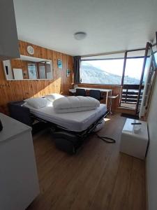 ein Schlafzimmer mit einem großen Bett in einem Zimmer in der Unterkunft STUDIO DE LA BICHETTE in Besse-et-Saint-Anastaise