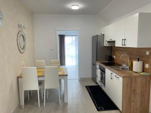 eine Küche mit einem Tisch und weißen Schränken in der Unterkunft Apartament Wierzawice in Wierzawice
