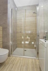 een badkamer met een douche, een toilet en een wastafel bij Urban Jungle - Sara Apartment in Białystok
