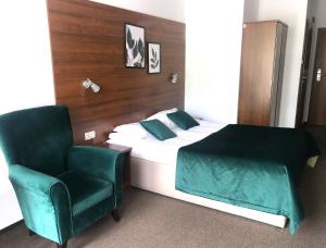 1 dormitorio con 1 cama y 1 silla verde en Dwa Potoki en Karpacz