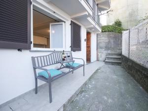 a bench sitting on the porch of a house at Bellano Holidays - Casa Ortensia in Bellano