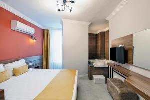 a hotel room with a bed and a flat screen tv at Terra Rossa in Antalya