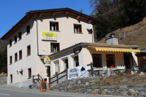 un edificio sul fianco di una collina con un cartello di Hotel Sfazù a Poschiavo