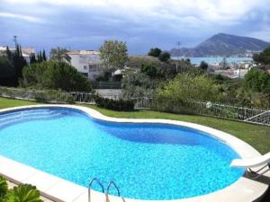 una gran piscina azul con vistas al océano en Bonito apartamento con inmensa terraza y piscina en Altea