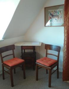 Gästewohnung SEETOR في Lenzen: غرفة بها كرسيين وطاولة في العلية