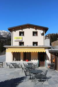 a building with tables and chairs in front of it at Hotel Sfazù in Poschiavo