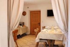 een eetkamer met 2 tafels en een deur bij Hotel Sfazù in Poschiavo