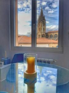 uma vela sentada numa mesa de vidro em frente a uma janela em Apartamento Wamba - La Catedral em Oviedo