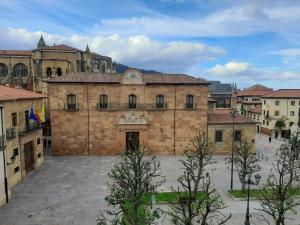 un gran edificio de ladrillo con un patio en una ciudad en Apartamento Wamba - La Catedral, en Oviedo