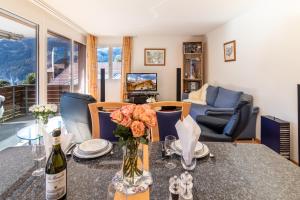 a living room with a table with a bottle of wine at Chalet Hannegg 2 in Wengen