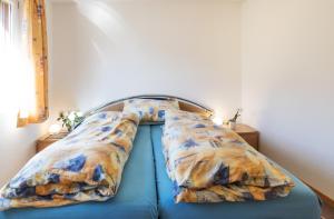 a blue bed with pillows on top of it at Chalet Hannegg 2 in Wengen +22 photos