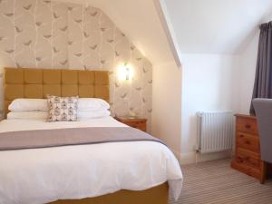 a bedroom with a large bed with a large headboard at The Cliffbury in Llandudno