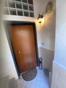 bagno con porta marrone e pavimento piastrellato. di Casa vacanze LaCorte ByFrancy a Bari