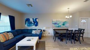 a living room with a blue couch and a table at BC508 Townhome with Beach Inspired Decor, Heated Pool with Water Slide in Port Aransas