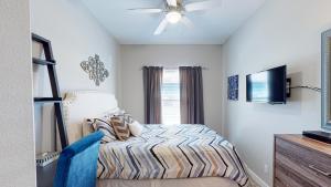 a bedroom with a bed and a flat screen tv at BC508 Townhome with Beach Inspired Decor, Heated Pool with Water Slide in Port Aransas
